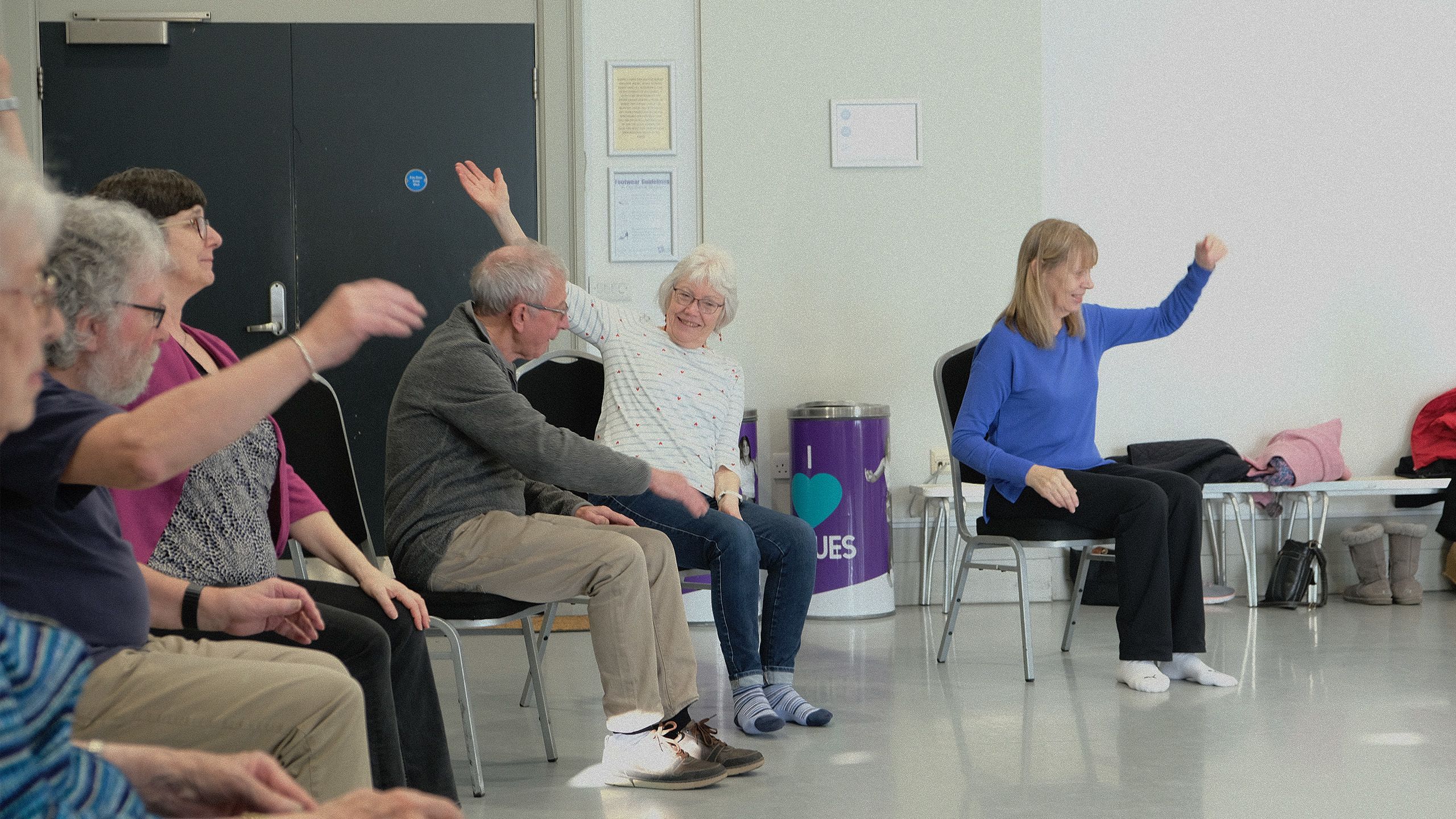 Parkinson's dance attendee smiling raising hand